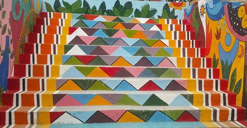 Những bậc tam cấp được hô biến thành bức tranh tường rực rỡ sắc màu, tạo điểm nhấn thi vị bên bờ sông Cẩm Lệ
