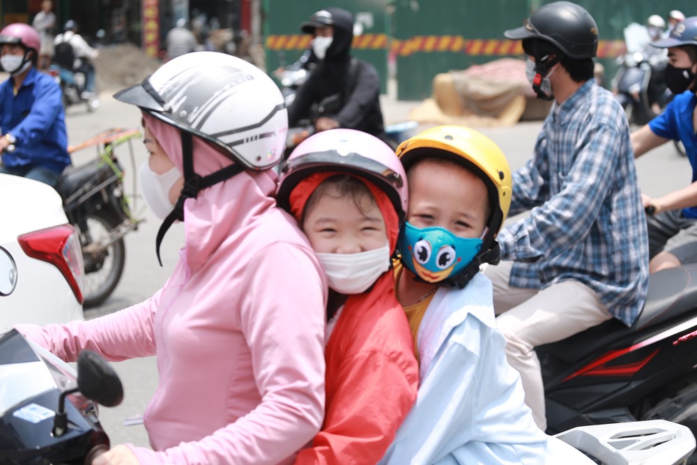 Nắng nóng oi bức, người dân Hà Nội ra đường bịt kín mít