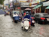 Người dân TP HCM lội nước về nhà sau cơn mưa lớn
