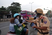 CSGT phát nước uống, mũ bảo hiểm cho người dân về quê đón Tết