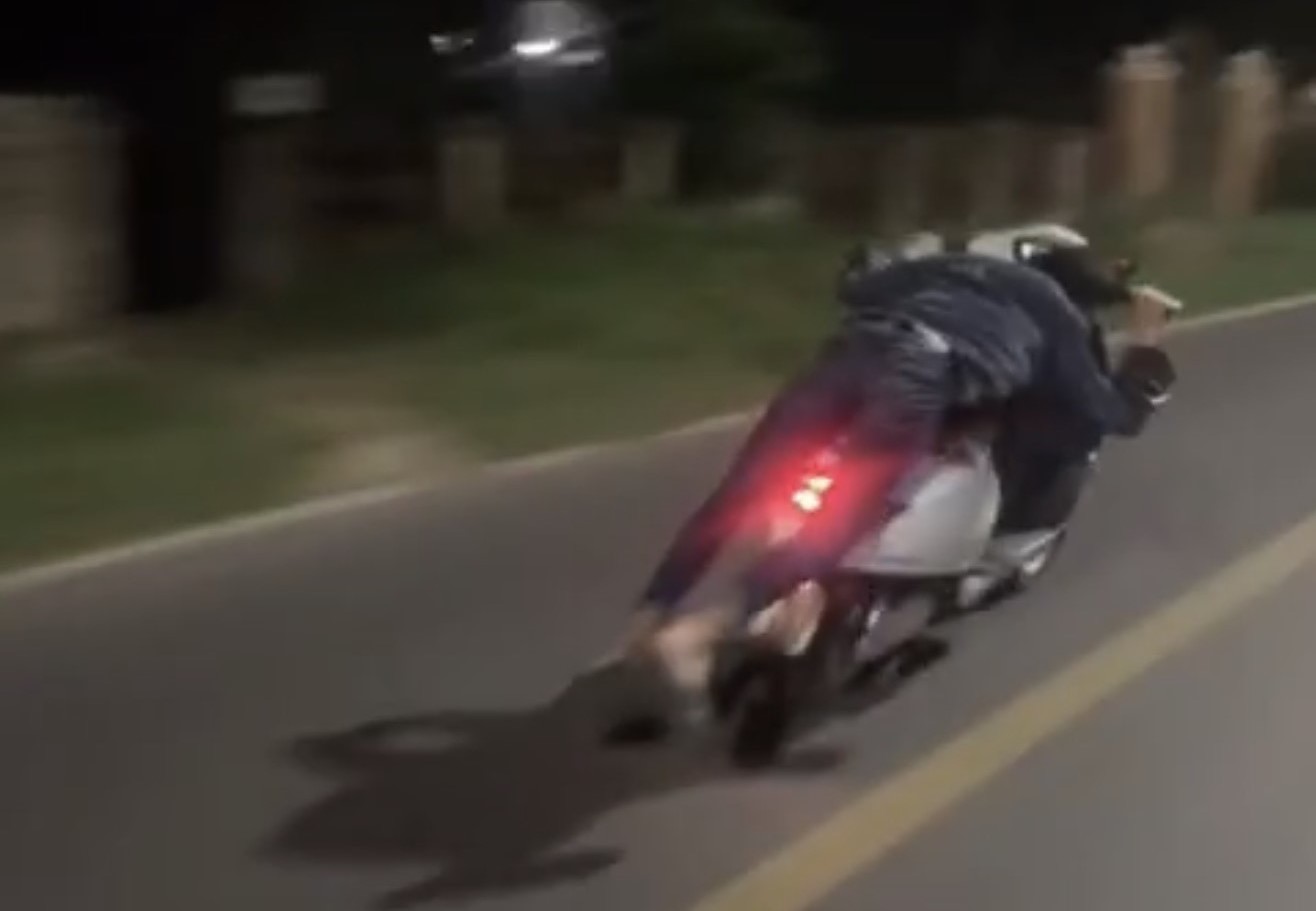 Nằm trên yên điều khiển xe máy điện, một thiếu niên bị tịch thu phương tiện