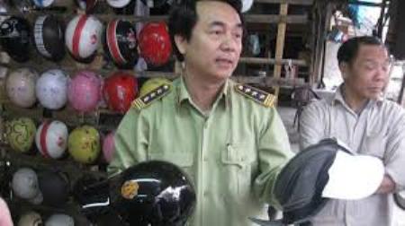 Trần Hùng - Phó Cục trưởng Cục Quản lý Thị trường đang trao đổi về mũ bảo hiểm giả. Ảnh: Thế Lữ