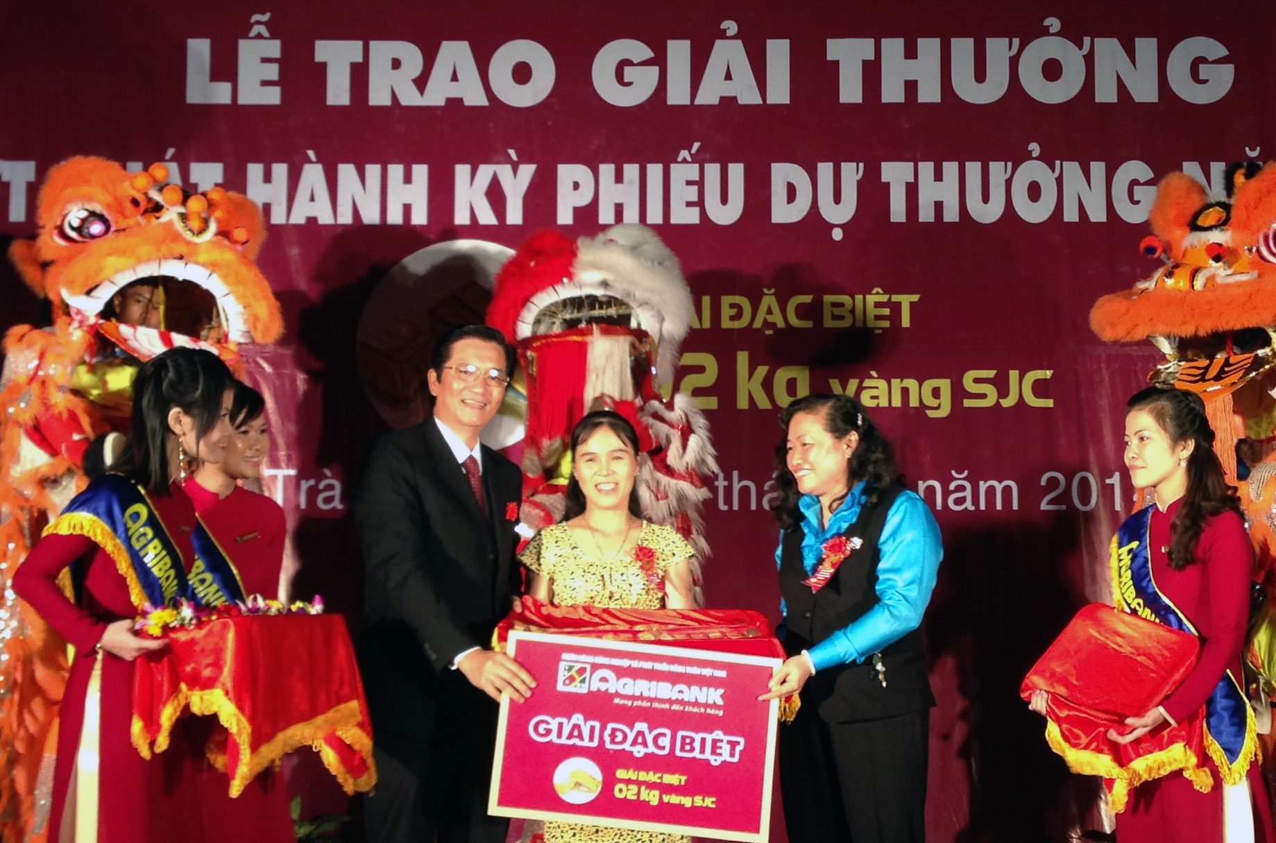 Ông Trần Ngọc Hải - Phó Trưởng Văn phòng đại diện khu vực miền Nam Agribank và bà Bùi Thị Sáu - GĐ Ngân hàng Nhà nước tỉnh Trà Vinh trao giải đặc biệt 2kg vàng SJC cho khách hàng.