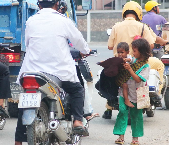 Mẹ mìn ngồi hóng mát, trẻ đứng giữa nắng Sài Gòn xin tiền