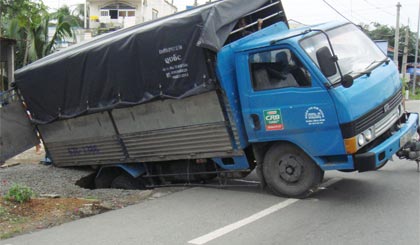 Xe chở gạo sụp cống
