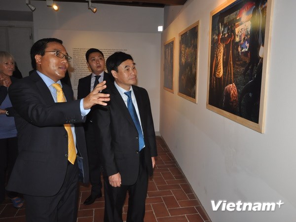  Thứ trưởng ngoại giao Hồ Xuân Sơn và Đại sứ Việt Nam tại Italy Nguyễn Hoàng Long xem ảnh triển lãm của Paolo Belletti. (Ảnh: Trịnh Minh Đức/Vietnam+)