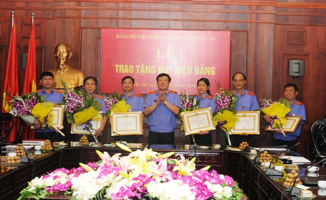  Đồng chí Nguyễn Hòa Bình, Ủy viên trung ương Đảng, Bí thư Ban cán sự Đảng, Viện trưởng VKSNDTC trao tặng Huy hiệu 30 năm tuổi Đảng cho các đảng viên 