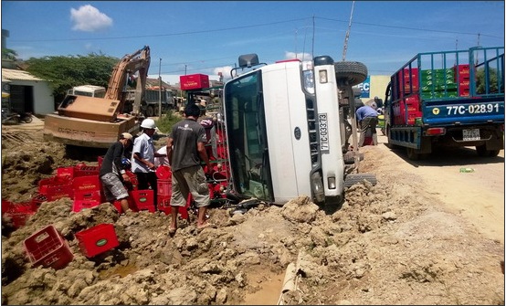 Lật xe tải chở bia, người dân giúp tài xế gom lại tài sản