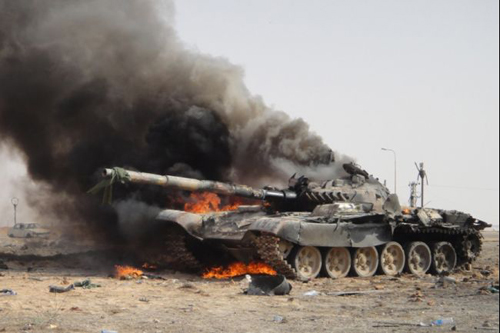Xe tăng của lực lượng trung thành với nhà lãnh đạo Libya Moammar Gadhafi bốc cháy vì bị không kích vào tháng 3/2011. Ảnh: Global Post