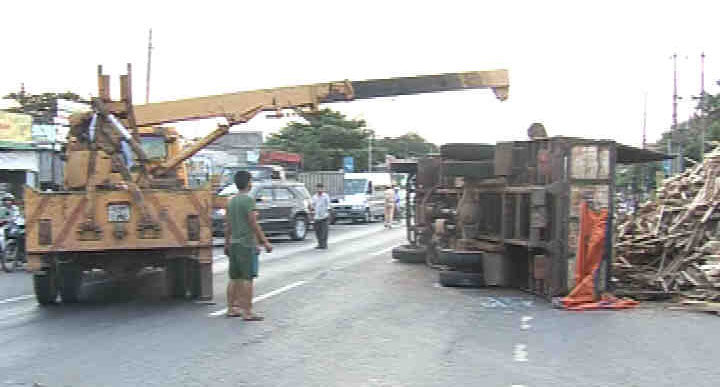 Xe tải chở gỗ cao su bị lật