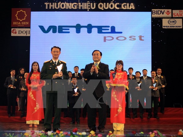 Ông Hoàng Trung Hải, Phó Thủ tướng Chính phủ trao biểu trưng thương hiệu quốc gia cho doanh nghiệp Viettel post. (Ảnh: Vũ Sinh/TTXVN)