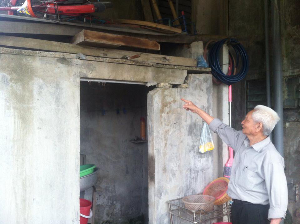 Ông Nguyễn Quang Ty và một phần công trình nhà bị nghiêng, lún, nứt.