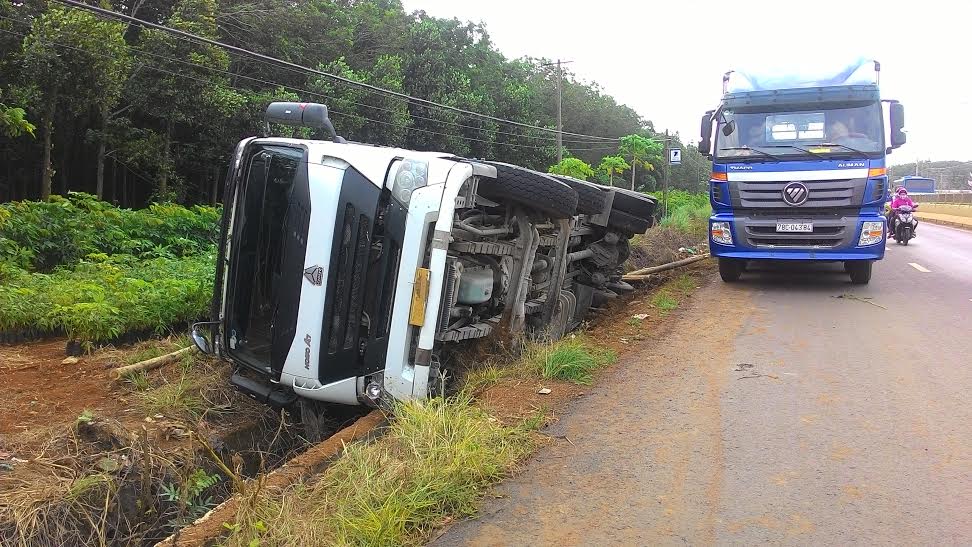 Xe tải chở gỗ lật xuống mương