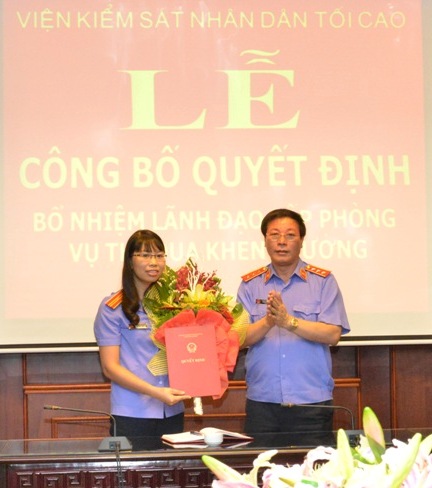  Tiến sỹ Nguyễn Hải Phong, Phó Viện trưởng Thường trực VKSNDTC trao quyết định và tặng hoa chúc mừng đồng chí Ngô Thị Xuân Huyên.
