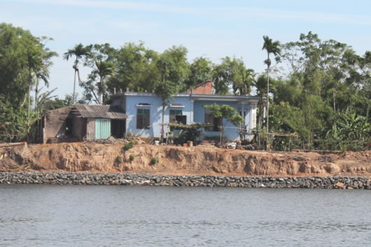 Một ngôi nhà ở thôn Trà Liên Đông sắp rơi xuống sông do bờ sông bị sạt lở.