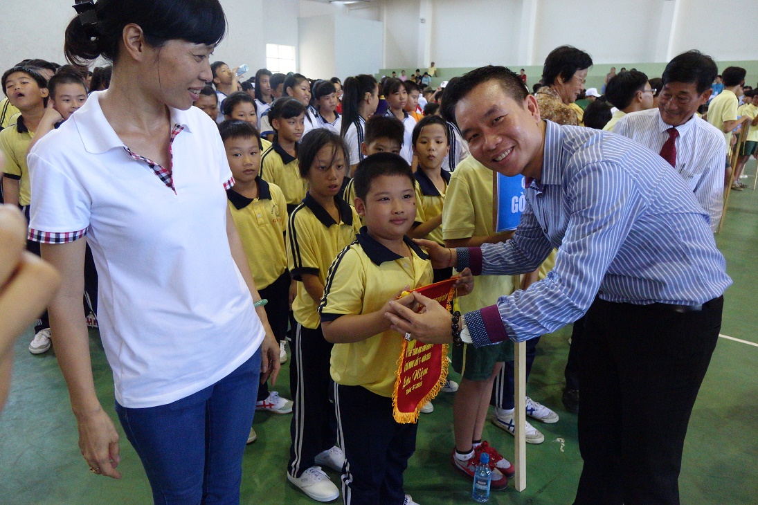 Ông Trương Văn Toàn, Giám đốc Đối ngoại & Pháp Lý trao cờ lưu niệm cho các học sinh tham gia Ngày Hội thể thao học sinh khuyết tật TP.HCM lần V năm 2016