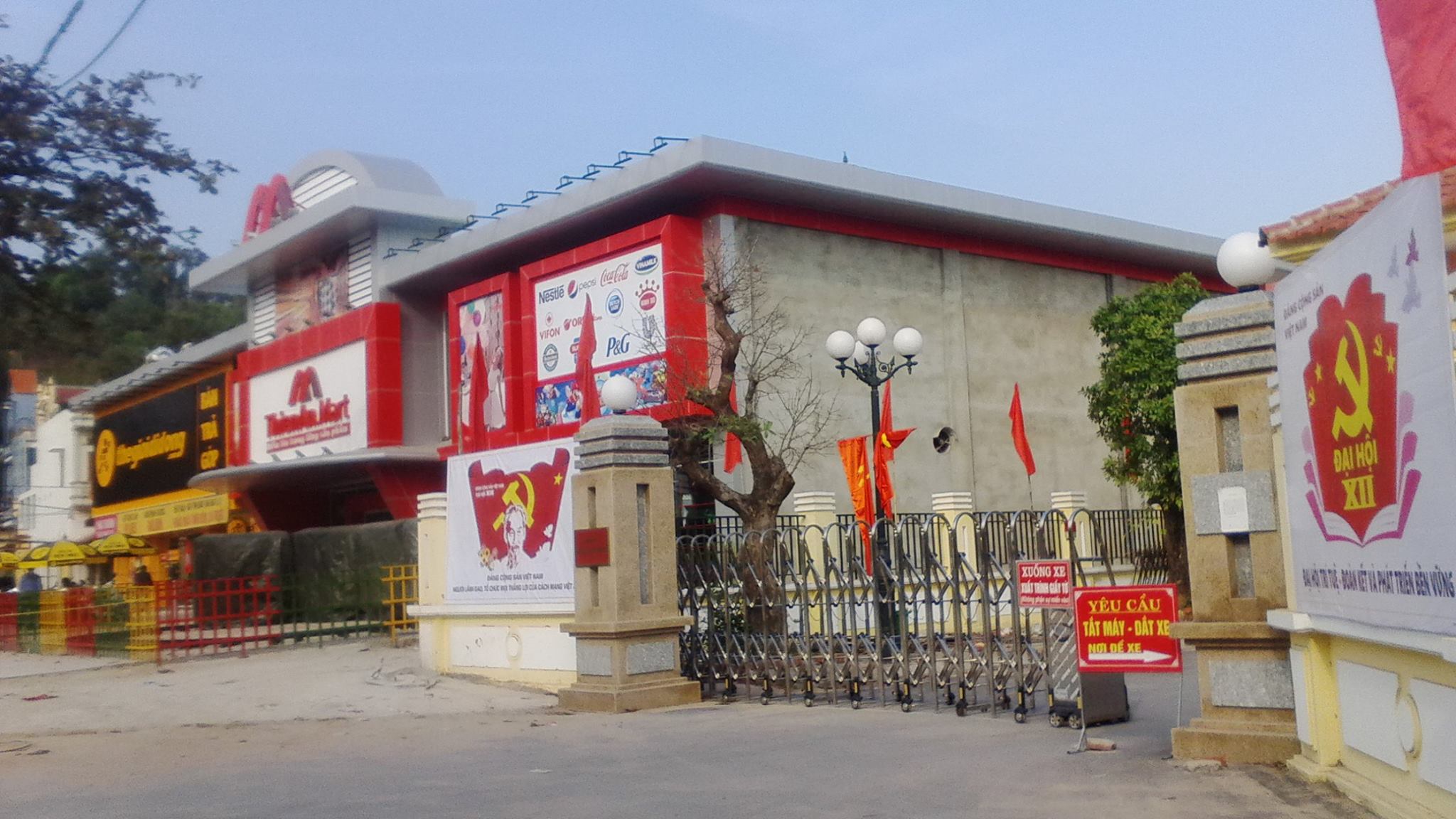 Tấm biển Chân dung Chủ tịch Hồ Chí Minh kinh yêu và đại hội lần thứ XII bị “pha tạp” bởi những biển quảng cáo gây mất mỹ quan