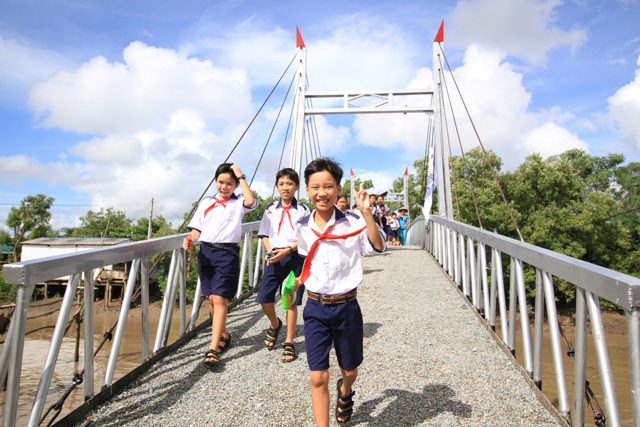 Những em học sinh của trường tiểu học Hiệp Vinh vui mừng đi trên cây cầu mới