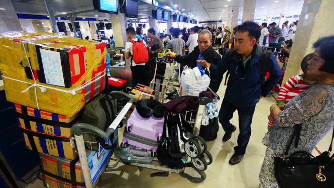 Sân bay Tân Sơn Nhất dịp tết hay quá tải là không tránh khỏi. Nhiều hãng hàng không có nguy cơ không được cấp phép tăng chuyến dù đã bán vé. Trong ảnh: hành khách làm thủ tục lên máy bay tại sân bay Tân Sơn Nhất