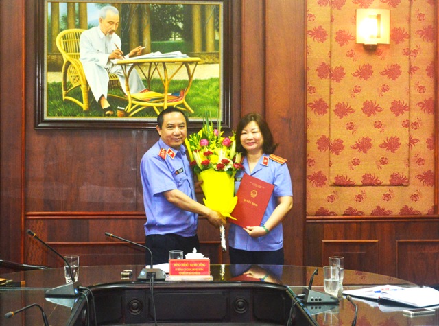 Đồng chí Bùi Mạnh Cường, Phó Viện trưởng VKSNDTC trao quyết định bổ nhiệm và tặng hoa chúc mừng đồng chí Trần Thị Quế Anh